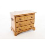 A Victorian pine apprentice chest, with three long drawers, applied with hardwood button handles and