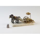 A late 19th century Palais Royale gilt metal thimble chariot, formed as a carriage drawn by two