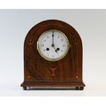 An Edwardian walnut mantel clock, of arched form with a 10cm white enamelled dial and two train