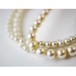 A single strand graduated cultured pearl necklace, with attached white metal clasp stamped '9ct',