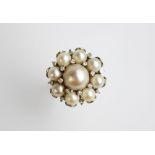 An untested pearl and diamond cluster dress ring, 1960's, designed as a central pearl within diamond