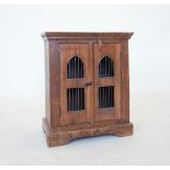 An Indian hardwood cabinet, the two doors inset with iron bar grilles, applied with a clasp lock and