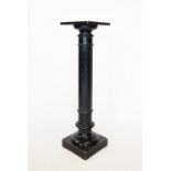 A Victorian ebonised pedestal, the square top raised upon a fluted cylindrical column and square