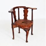 A George II mahogany corner elbow chair, the curved crest rail raised upon a pair of vase shaped