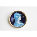 An enamel on copper Limoges style brooch depicting a female classical warrior, of circular form
