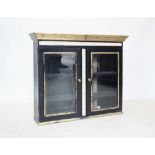 A 19th century and later painted glazed wall cabinet, in a neoclassical style, painted in black with