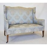 An Edwardian mahogany two seater sofa, the serpentine padded back with shaped wing backs above