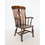 A Victorian elm and beech wood Windsor elbow chair, the top rail carved with foliate decoration