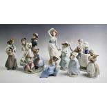 A Lladro figure of a girl holding a basket with three puppies, a Nao group, a young dancing