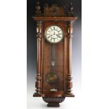 A Victorian walnut Vienna wall clock, the architectural case with turned fluted columns flanking the