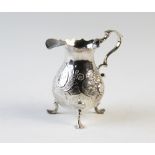 A George II silver milk jug, William Coles London 1744, of typical form with three scroll legs with