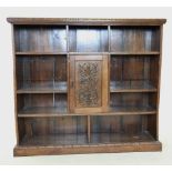 A late Victorian carved oak open bookcase, the rectangular moulded top with a carved border above an