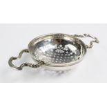 A George II silver lemon strainer, Dinah Gamon, London 1740, of typical form with foliate pierced