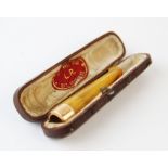 A 15ct yellow gold mounted amber cheroot, 5.7cm long, weight 6.3gms within fitted case
