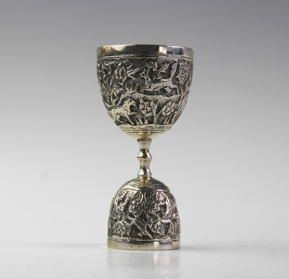 An Anglo-Indian silver double egg or wager cup, each bowl chased with a continuing landscape of