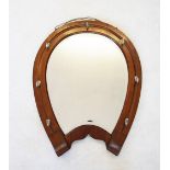 An early 20th century walnut framed horse shoe mirror, the shaped bevelled mirror plate within a