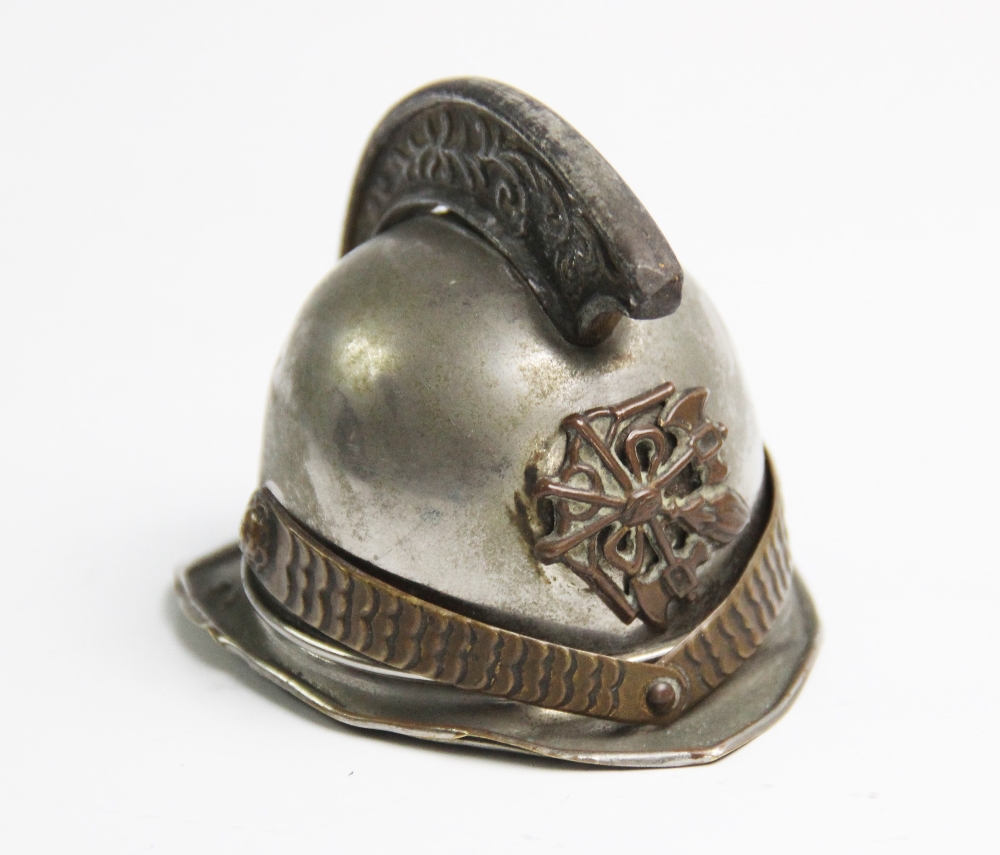 An early 20th century novelty French fireman's helmet match holder or vesta, applied with front