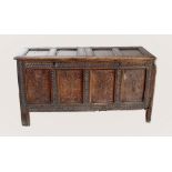 A late 17th/early 18th century carved oak twin compartment coffer, the twin two panel lids mounted