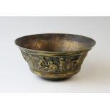A brass bowl 19th century, the flared rim cast with a continuous frieze of frolicking bacchanalian