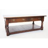 A reproduction oak coffee table, 20th century, the rectangular top raised upon ring turned