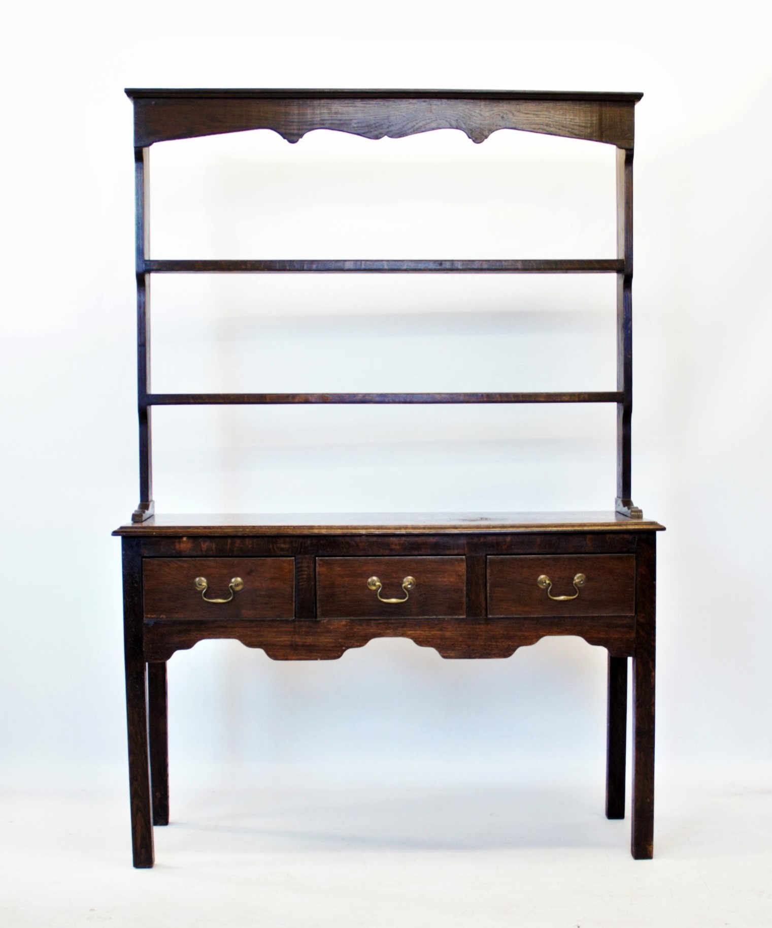 An 18th century style oak dresser, 20th century, with an open plate rack above a rectangular moulded