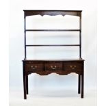 An 18th century style oak dresser, 20th century, with an open plate rack above a rectangular moulded