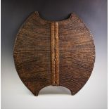 A Mambila 'Kor' Shield, Cameroon, with wood and braided palm fibre body, decorated with geometric