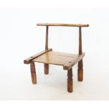 A late 19th/ early 20th century primitive chair, Ivory Coast, Dan Tribe, the curved top rail on