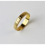 A yellow gold band, possibly a posy or posie ring, with decoration to the exterior and stamped '