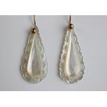 A pair of mother of pearl earrings, each designed as a pear shaped drop with carved and pierced