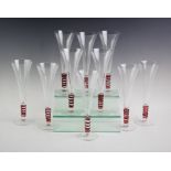 A set of ten LSA champagne flutes, each clear glass with a trailed red glass stem, 24cm high (10)
