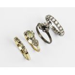A group of four rings, to include; a paste set solitaire stamped '9ct', weight 2.5gms, a full hoop