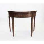 A George III mahogany cross banded demi-lune folding games table, the circular baize lined top