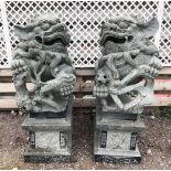 A very large pair of carved granite Dog of Fo sculptures, each confronting lion holding a puzzle