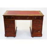 An early 20th century oak twin pedestal desk, with a leather inset top above three frieze drawers,