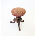 A Victorian rosewood revolving piano stool, the upholstered circular seat raised upon a lobed and