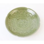 A Chinese Yaozhou celadon bowl, the circular bowl with cusped rim decorated with central prunus