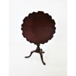 A George III mahogany pie crust tripod table, the circular top with a scalloped raised rim, on a