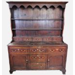 A late 18th century oak Welsh dresser, with a moulded cornice above a scalloped frieze, two
