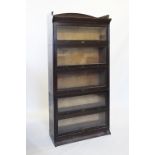 An early 20th century oak five tier 'Lebus' stacking bookcase, with a tray top above five 'up and