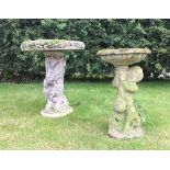 A reconstituted stone bird bath, designed as a cherub supporting a bowl shaped bath, 62cm high, with