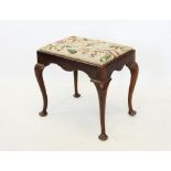 An early 20th century Queen Anne style walnut dressing stool, the rectangular tapestry top raised