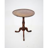 A George III mahogany tray top tripod table, the circular top with a moulded raised edge, upon a