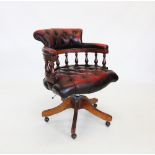 An oxblood red leather revolving desk chair, late 20th century, with button back seat and padded