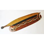 An Australian Aboriginal painted shield with traditional snake and dot design, 62.5cm long, with