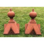 A pair of terracotta coloured, gate capitals/finials, each of architectural form, tapering square