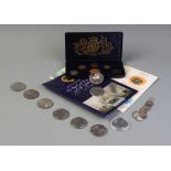 A selection of coins to include an enamelled 1887 crown brooch, twenty six pre-1944 threepences, a