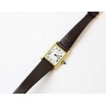 A lady's gold plated Cartier Tank wristwatch, the rectangular cream dial with black Roman