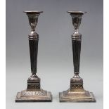 A pair of old Sheffield plate candlesticks, of Neoclassical form with tapered fluted columns upon