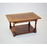 A honey oak coffee table, late 20th century, the rectangular top raised upon turned tapering